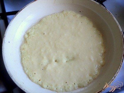 В сковороде разогреть растительное масло. Выложить по центру немного теста и быстро распределить его ложкой в тонкий пласт.