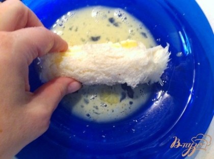 Скручиваем хлеб с сыром в трубочку, обмакиваем в яйцо,