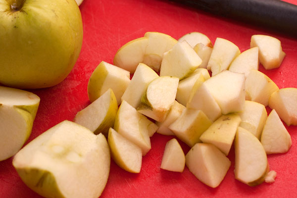 Яблоки очищаем и режем кубиками. Сразу выкладываем в форму для выпечки, смазанную маслом.