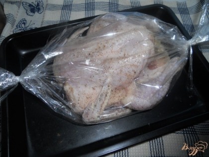 Укладываю курицу в пакет для запекания, завязываем. Упакованную тушку кладу на противень для духовки. Сверху делаю несколько небольших надрезов. Запекаю курицу в духовке при температуре около двухсот градусов 45-50 минут.