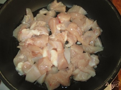 Мясо курицы (я использовала куриную грудку) порезать на небольшие кусочки. Уложить на смазанную маслом сковороду и ставим на огонь.