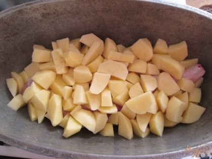 Затем положить порезанный крупными кубиками картофель.