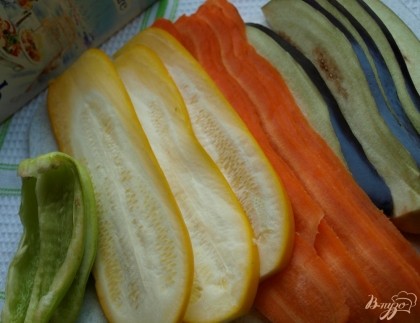 Тонкими пластинами нарезаем овощи: баклажан, кабачок и морковь. Перец разрезаем на 4 части вдоль.