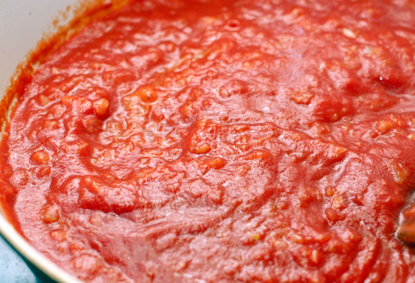 Когда лук станет мягким, добавьте томатное пюре, доведите до кипения и готовьте 3-4 минуты не небольшом огне. Обратите внимание, что речь идет именно о пюре, а не о томатной пасте. Пюре можно взять готовое или сделать самостоятельно из спелых помидоров.