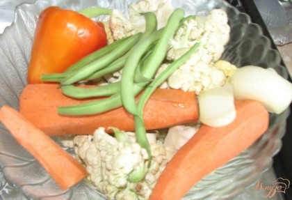 Берем любимые овощи (желательно купленные на рынке, а не в супермаркете) или те, что есть в холодильнике и тщательно их моем. Я начала с цветной капусты, моркови, стручковой фасоли и перца. Цветную капусту разрезаем на соцветия, перец режем дольками, морковь нарезаем кусочками или кружочками. Выкладываем все порезанные овощи на противень, предварительно застеленный фольгой, чтоб блюдо не пригорело.