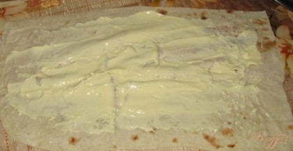 Берем лаваш и тонким слоем намазываем на него слой плавленого сыра.