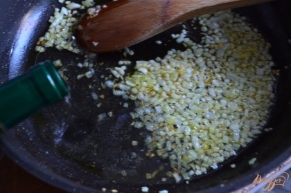 На оливковом масле обжарить до прозрачности луковицу, нарезанную мелко. Влить вино и тушить 7-10 мин.