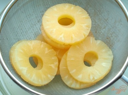 С ананасов слить сироп и немного отжать чтоб было меньше влаги.Выложить в сито чтоб жидкость ещё стекла.