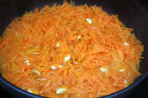 Теперь делаем начинку. В сковороде с оливковым маслом и небольшим количеством воды тушим до мягкости мелко нарезанный чеснок и натертую морковь. Это займет 15-20 минут.