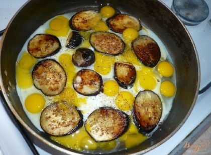 В сковороду к баклажанам добавляем перепелиные яйца. Так как для меня разбить 20 перепелиных яиц дело не быстрое, то на это время я снимаю сковороду с огня, или же, яйца можно разбить отдельно, в миску и вылить к баклажанам. Посыпаю солью и черным молотым перцем.