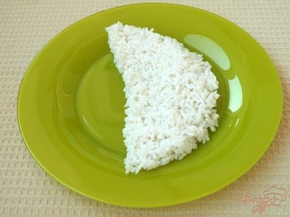 Взять плоское блюдо и выложить на него салат слоями. Каждый слой при этом нужно щедро смазать майонезом.Первым слоем выложить рис.