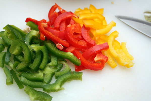 Разноцветные сладкие перцы нарезаем брусочками, очистив от семян.