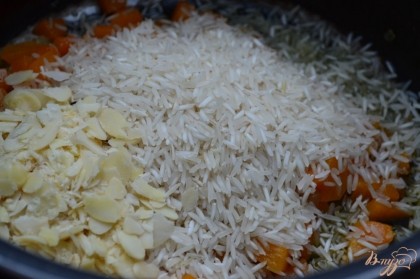 Насыпать рис и миндальные пластинки, перемешать и подержать на огне 2 минуты. Затем залить овощным бульоном.