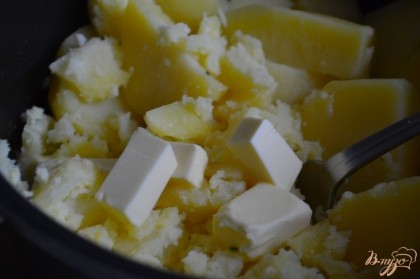 В горячий картофель добавить сливочное масло.Давить картофель удобно вилкой , оставляя небольшие кусочки.