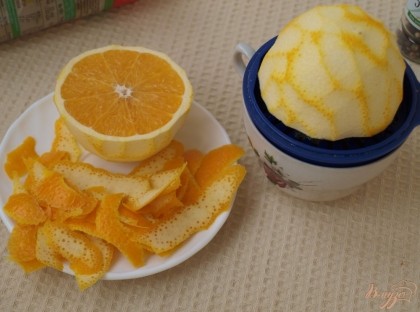 С помощью овощечистки с апельсина срезать цедру.Апельсин разрезать пополам и выдавить сок.
