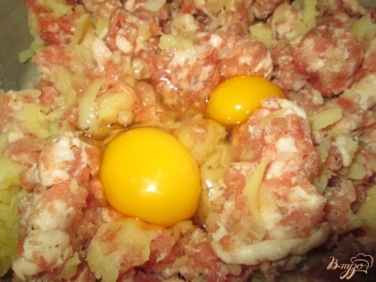 В фарш добавить два куриных яйца, натертый картофель,