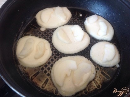 На разогретую сковороду с растительным маслом,  ложкой выкладываем небольшое количество теста, сверху выкладываем пару кусочков яблока