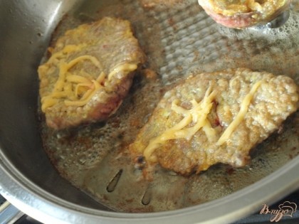 В сковороде разогреть подсолнечное масло и выкладывать в него отбивные.Прожарить одну сторону,затем перевернуть и посыпать сыром.