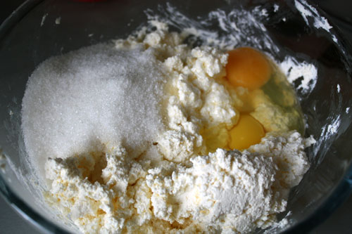 Размять творог вилкой так, чтобы оставались мелкие крупинки творога.<p>Добавить яйца и сахар (3-4 ст. л.), перемешать.