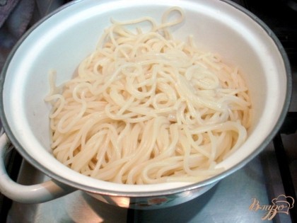 Откидываем на дуршлаг, а затем перекладываем в кастрюлю. Чтобы спагетти не слипались заправьте их столовой ложкой оливкового масла.