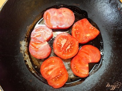 Сковородку смазываем растительным маслом и раскладываем кружочки помидоров.