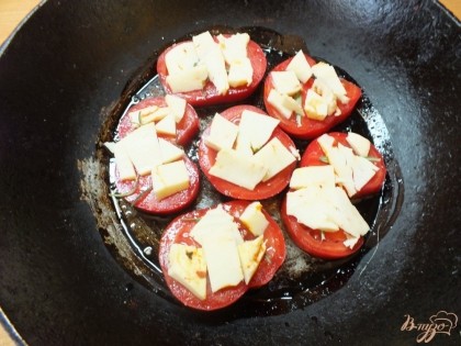 Разложите сыр равномерно на помидоры и посыпьте красным перцем. Запекайте около 15 мин при 180 градусах до мягкости помидор.