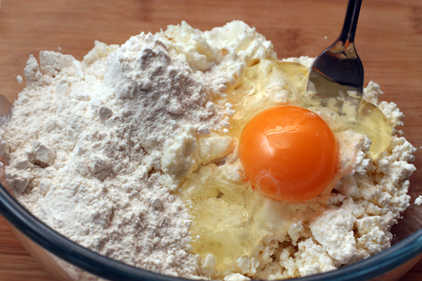 Смешайте творог с творожной массой и яйцом. Добавьте ванильный сахар или ванильный экстракт и три полные столовые ложки муки, хорошо размешайте.