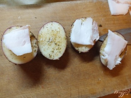 Нарезаем ломтиками сало, не слишком тонко и раскладываем на картофель через один.