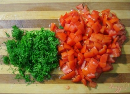 Нарежьте помидоры и зелень и добавьте их к капусте и желудочкам. Протушите вместе ещё 5-7 минут.