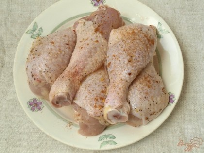 Куриные ножки вымыть, обсушить и натереть солью, перцем и приправами для курицы.