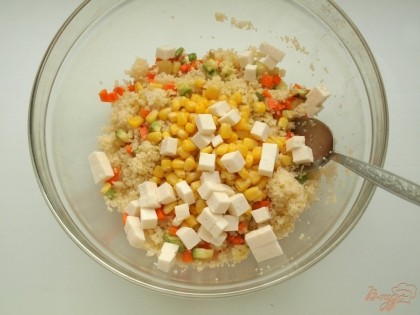 К кус-кусу добавить обжаренные овощи, кукурузу и нарезанную кубиками брынзу.