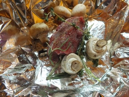 Шампиньоны вымойте и положите к мясу целиком (грибы берите мелкие либо крупные нарежьте пополам).