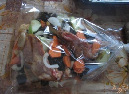 Укладываем куриную грудку, чернослив, яблоки, лук и морковь в пакет для запекания и закрываем его.