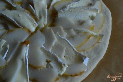 Тесто раскатать тонко и разложить кусочки сыра и тонкие дольки груши.