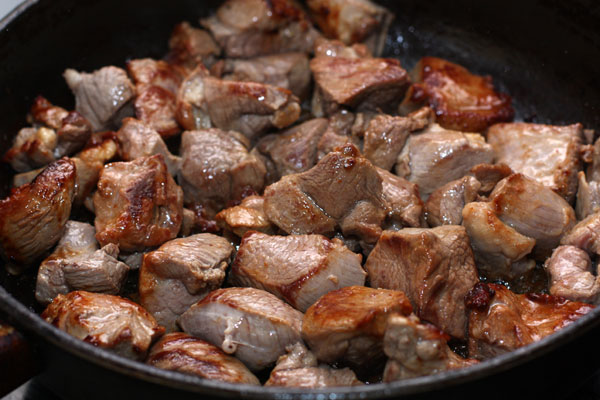 Когда мясо обжарится со всех сторон, посолите, поперчите, накройте его крышкой, убавьте огонь и готовьте 15-20 минут. При необходимости подлейте немного воды.