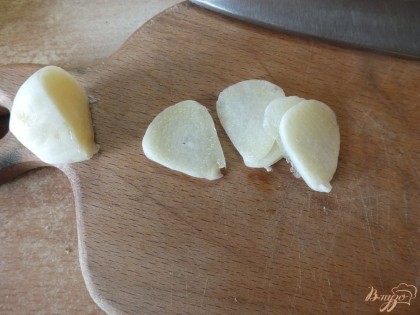 Половину зубчиков чеснок нарезаем тонкими ломтиками.