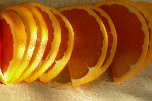 Апельсин режем на полукруглые ломтики.