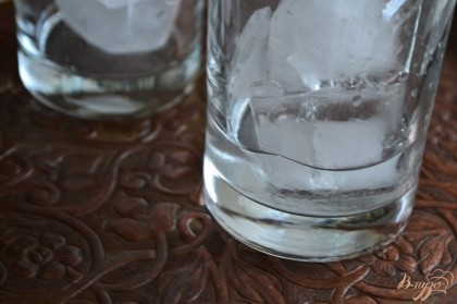 По стаканам разложить лед и налить водку. Наполнить апельсиново-дынной смесью.