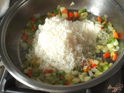 Пока рыба будет запекаться приготовить гарнир из риса.На оливковом масле немного обжарить нарезанный репчатый лук и болгарский перец.Затем добавить промытый рис.