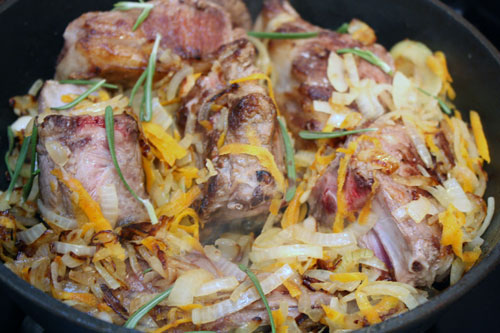 Лук тонко режем, морковь натираем на крупной терке. Добавляем в сковороду с мясом овощи. Готовим на среднем огне 5-10 минут, добавляем листочки розмарина.