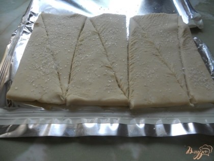 Когда тесто разморозится нарезаю его треугольниками. С одной стороны тесто щедро посыпаю сахарным песком. Конечно, не обязательно только сахаром, можно добавить, например, корицу.