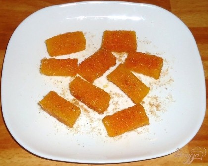 Коричневый сахар смешать с молотой корицей и обвалять кусочки тыквы.