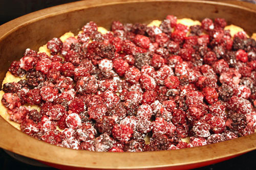 Испеченное тесто посыпаем молотым миндалем и выкладываем на него ягоды.