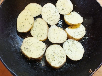 Выкладываем картошку в смазанную маслом сковородку и посыпаем солью, тимьяном.