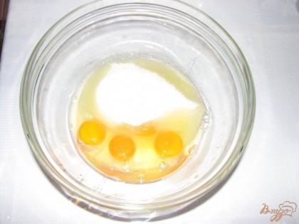Для приготовления пышной запеканки куриные яйца следует предварительно охладить в холодильнике, дабы они лучше взбивались. Кладем яйца в глубокую миску и добавляем сахар-песок. Взбиваем миксером на максимальной скорости до полного растворения сахара.