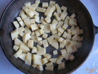Складываем подготовленный картофель на дно сковороды.