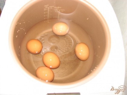 В чашу мультиварки кладем яйца и щедро заливаем их водой.