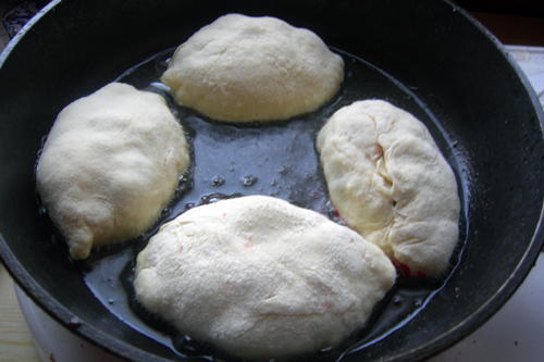 Нагреваем сковороду с достаточным количеством масла (дно точно должно быть покрыто полностью) и жарим пирожки на среднем огне под крышкой.