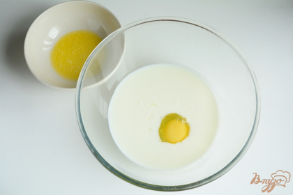 В отдельной миске смешиваем молоко, кефир и яйцо, добавить к этой смеси растопленное масло (необходимо остудить) и ванилин.