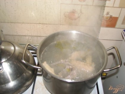 Готовим куриный бульон. Для этого в кипящую воду кладем суповой куриный набор и шинкуем луковицу. Варим на медленном огне 1 час. Вынимаем мясо из бульона и отделяем кости.